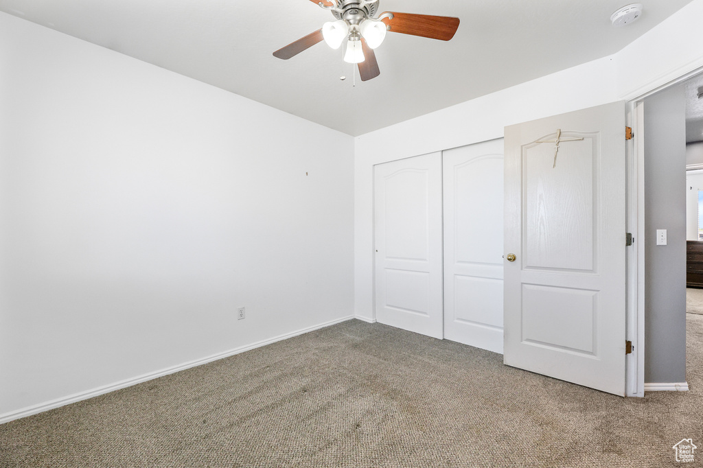 Unfurnished bedroom with a closet, carpet flooring, and ceiling fan