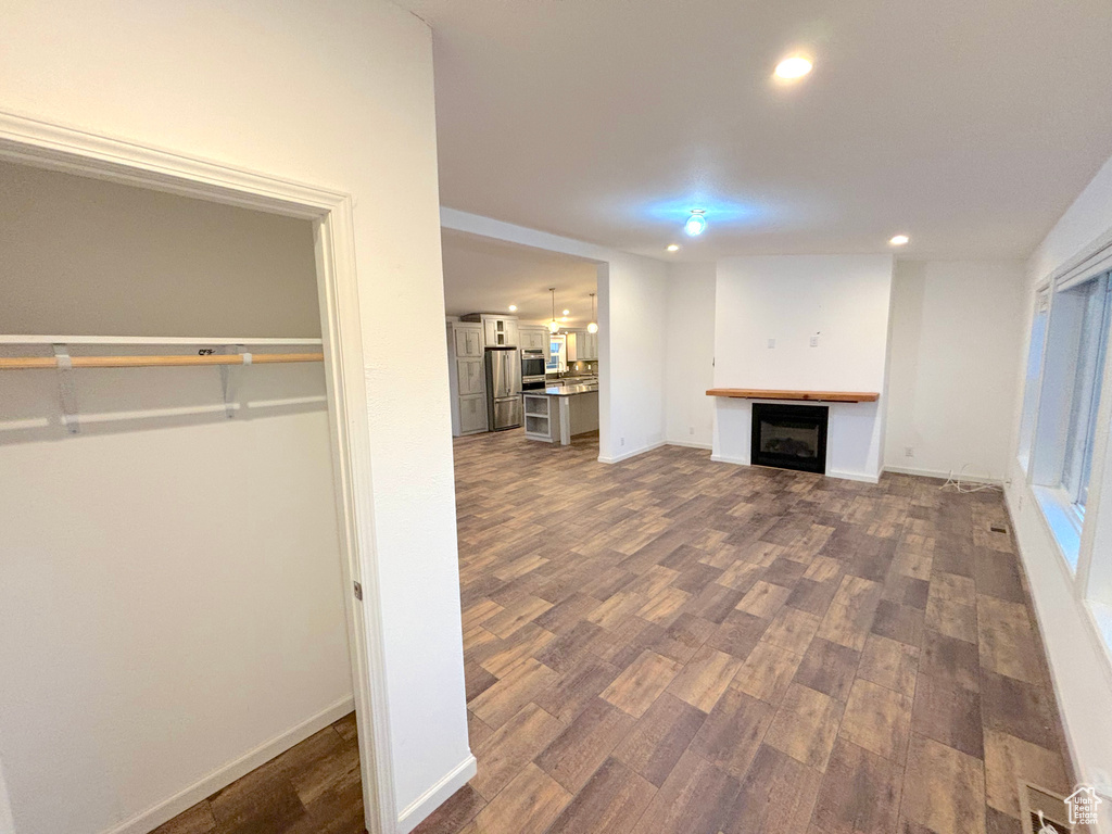 Unfurnished living room featuring dark wood-type flooring