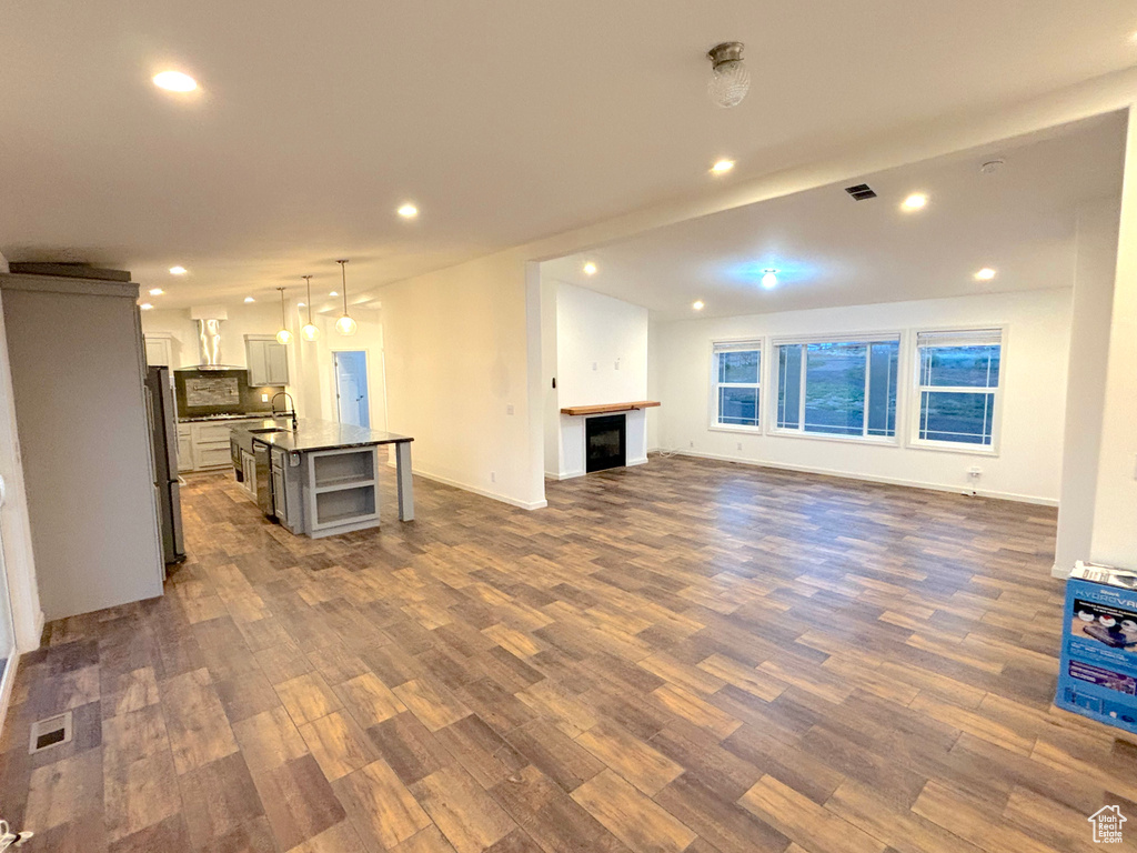 Unfurnished living room with sink and hardwood / wood-style floors