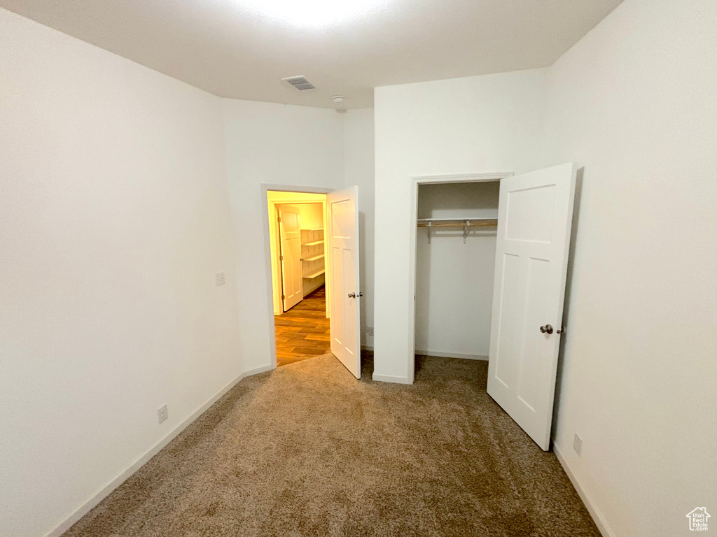 Unfurnished bedroom with a closet and carpet flooring