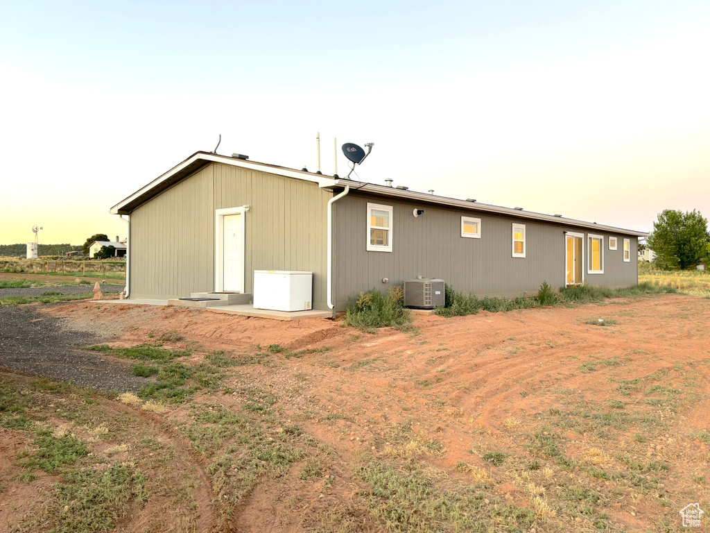 Back house at dusk featuring cooling unit