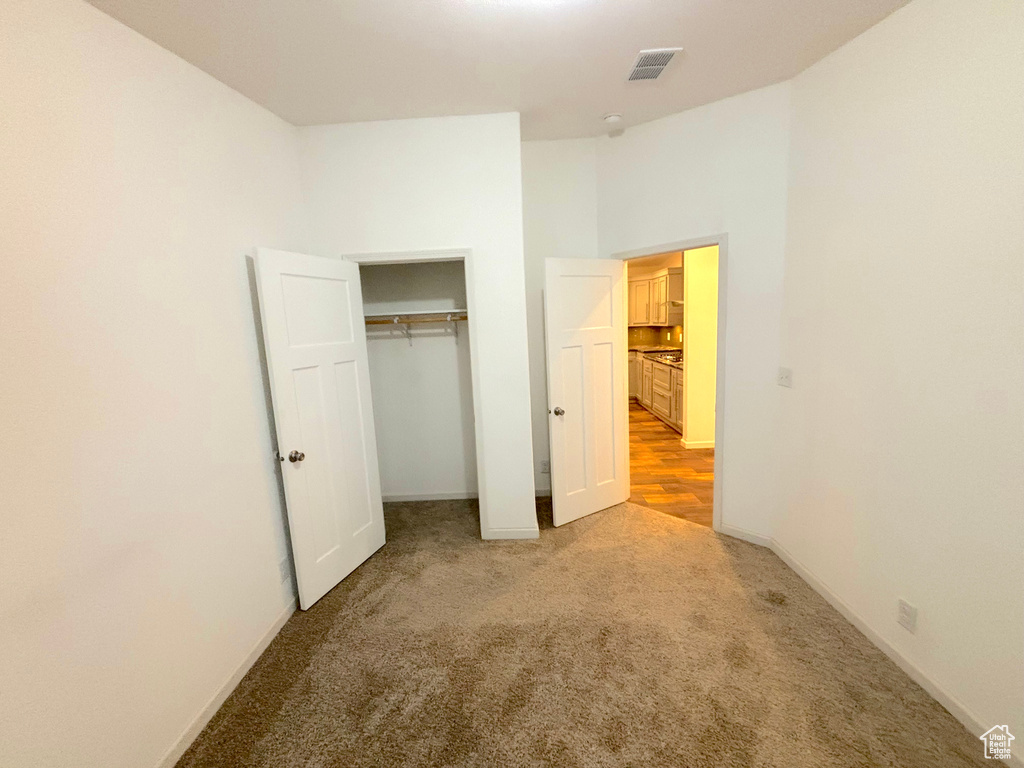 Unfurnished bedroom with carpet and a closet