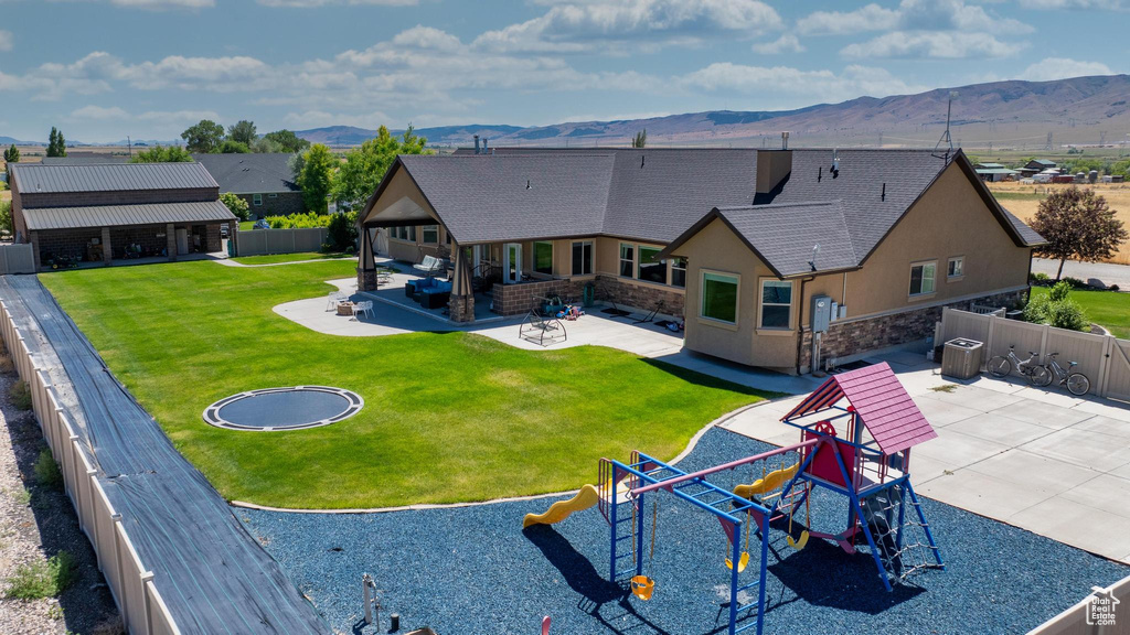 Exterior space featuring a patio, a lawn, and a mountain view