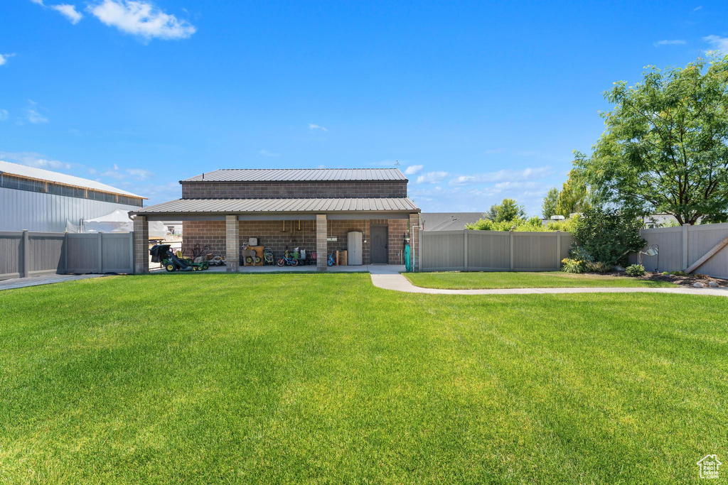 Rear view of property with a yard