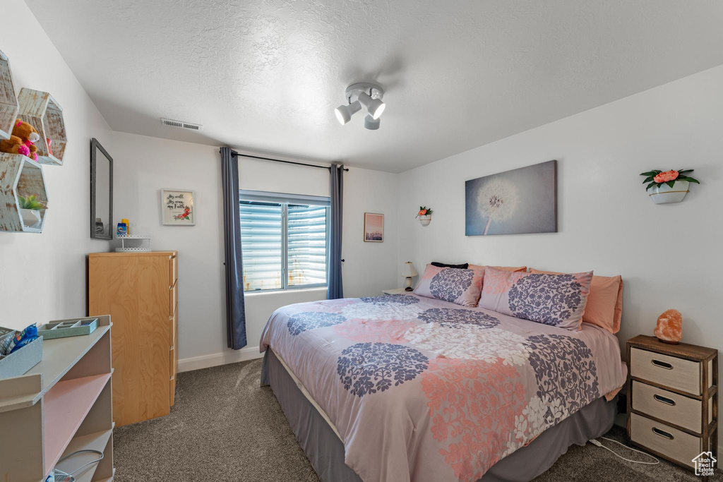 Bedroom featuring carpet flooring and a textured ceiling