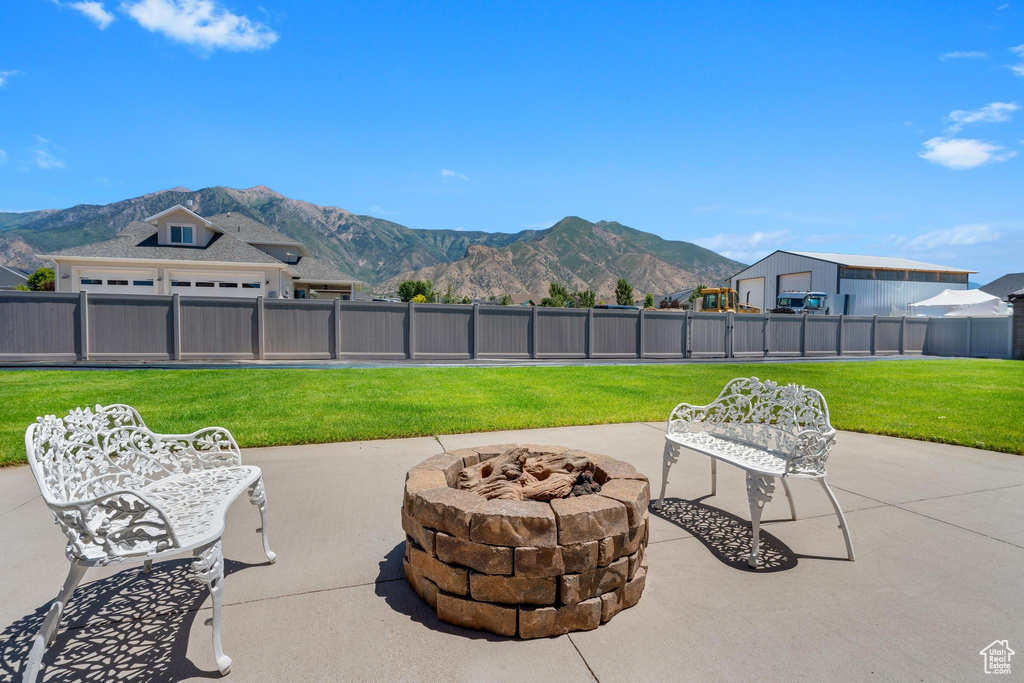 View of patio with a mountain view and an outdoor fire pit