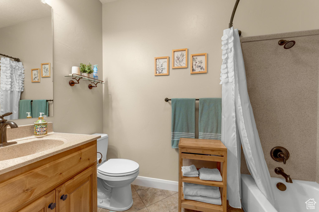 Full bathroom with toilet, vanity, tile patterned flooring, and shower / tub combo