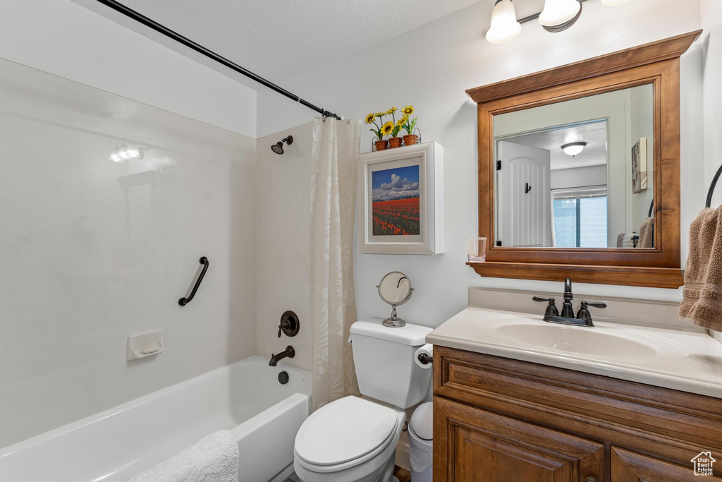 Full bathroom featuring vanity, toilet, and shower / bath combination with curtain