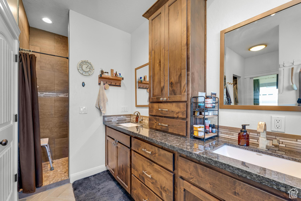 Bathroom featuring tile patterned flooring and double vanity