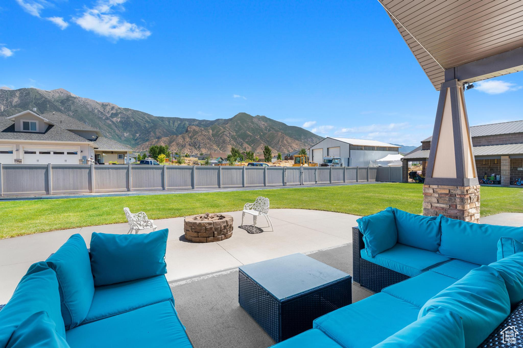 View of patio / terrace featuring an outdoor living space with a fire pit and a mountain view