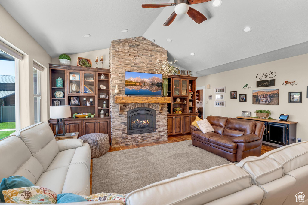 Living room with plenty of natural light, a fireplace, ceiling fan, and hardwood / wood-style floors