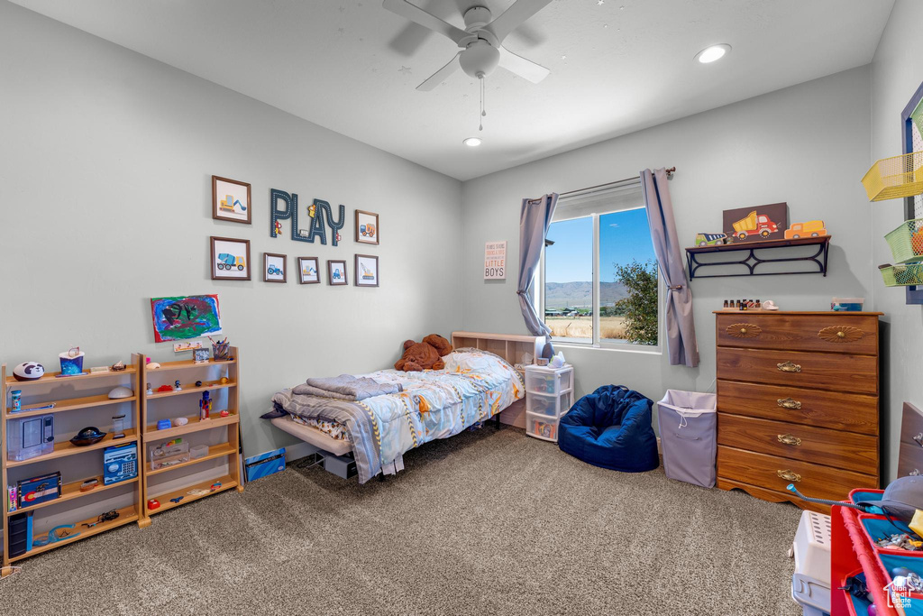 Carpeted bedroom featuring ceiling fan