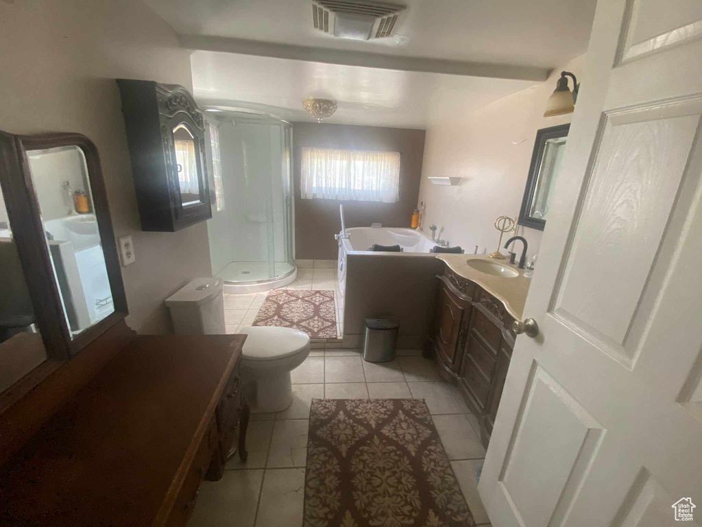 Full bathroom featuring vanity, plus walk in shower, tile patterned flooring, and toilet