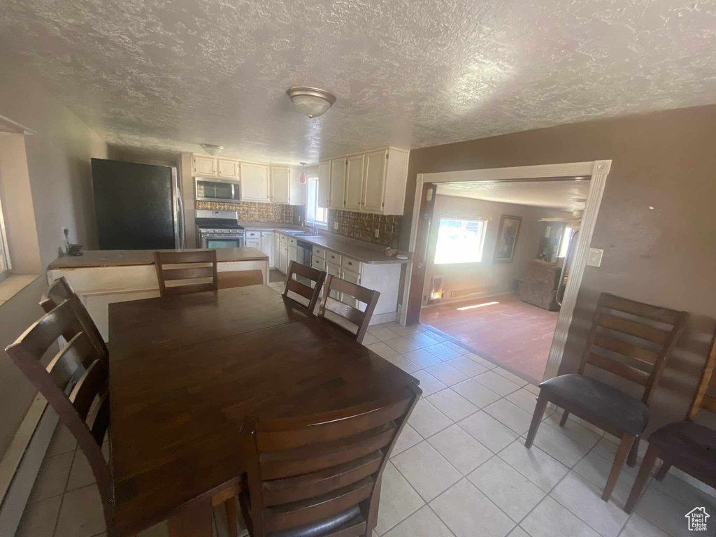 Dining area featuring light tile patterned flooring and a textured ceiling