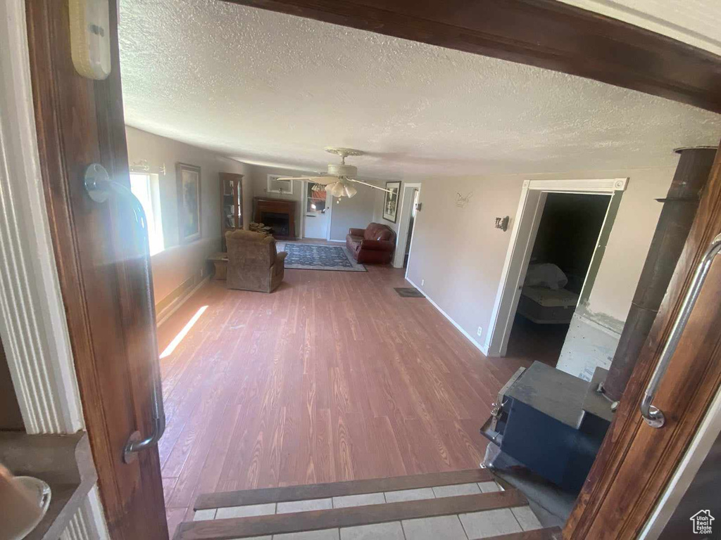 Interior space featuring a textured ceiling, wood-type flooring, and ceiling fan