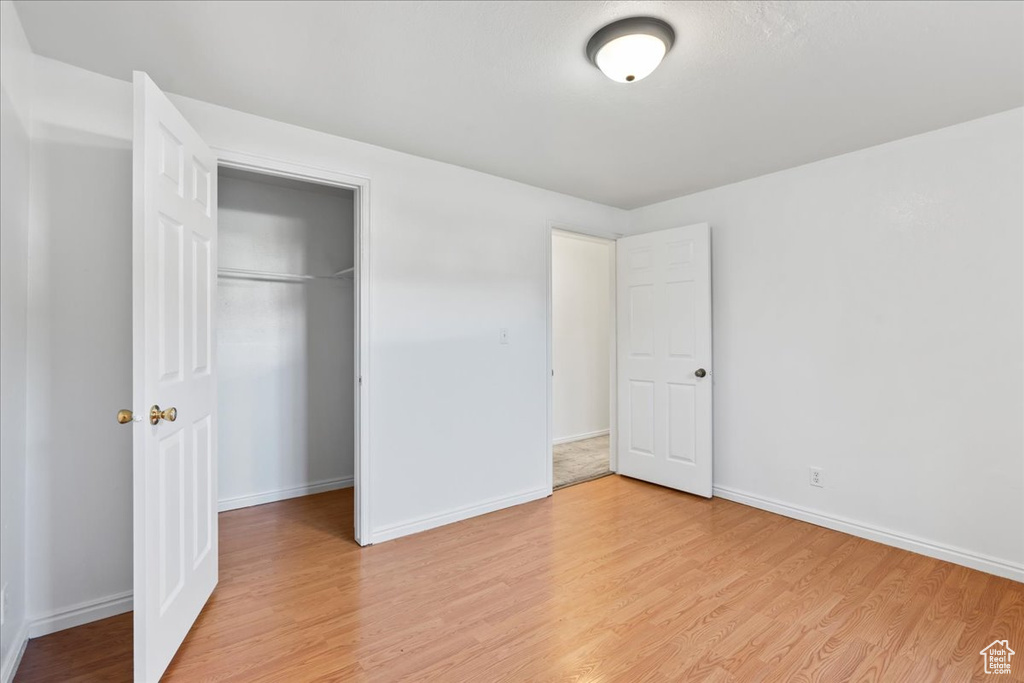 Unfurnished bedroom featuring light hardwood / wood-style floors and a closet