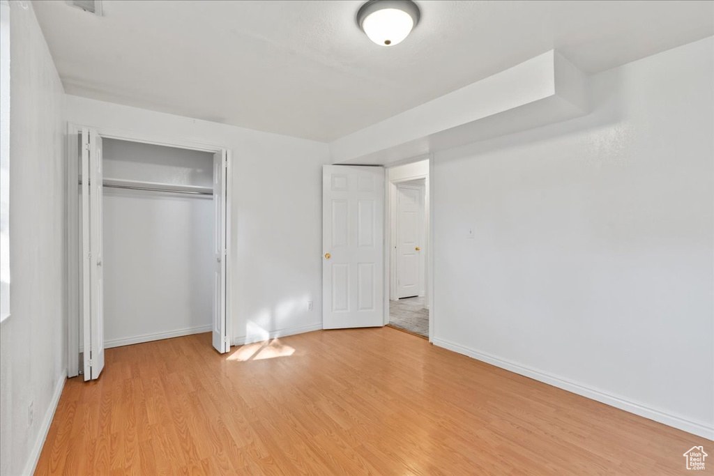 Unfurnished bedroom featuring a closet and light hardwood / wood-style floors