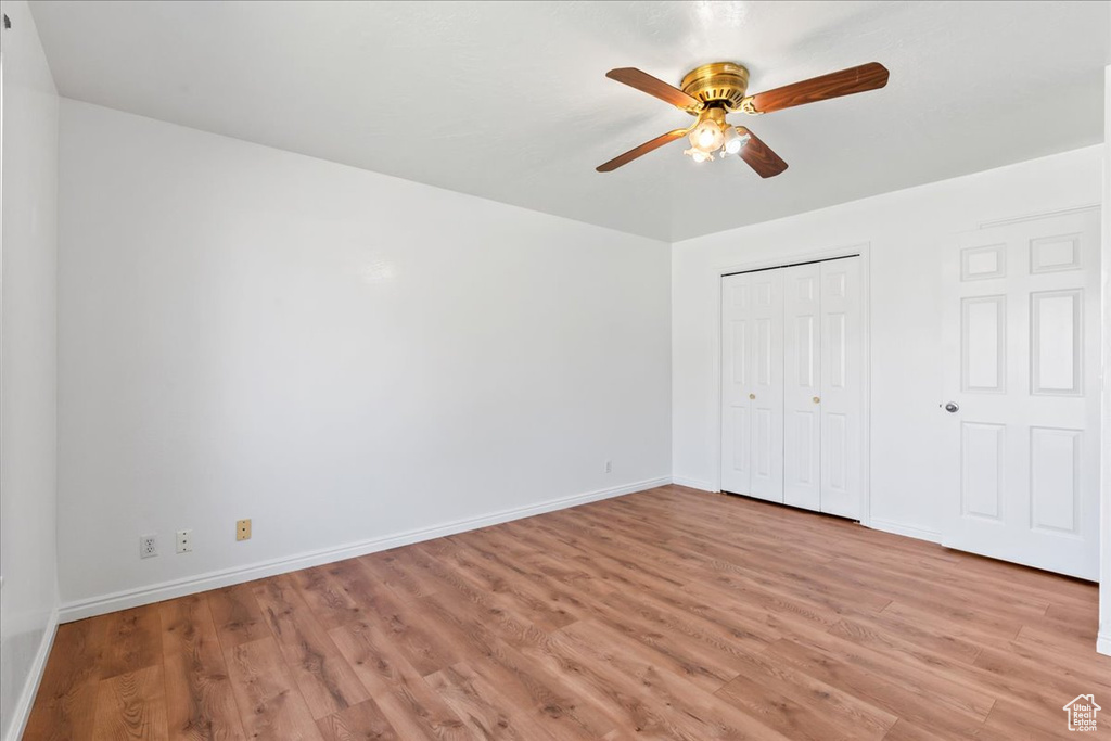 Unfurnished bedroom with a closet, light hardwood / wood-style floors, and ceiling fan