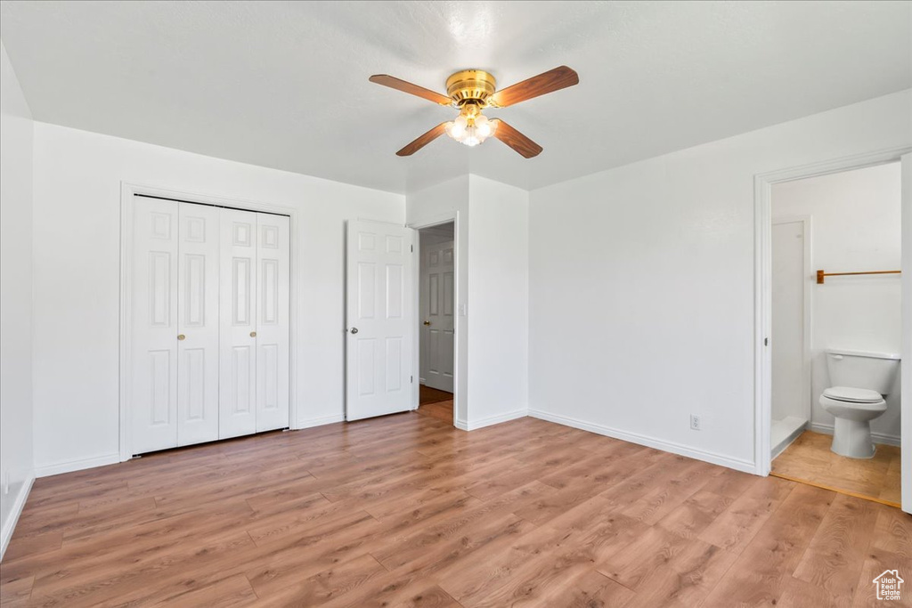 Unfurnished bedroom featuring connected bathroom, a closet, light wood-type flooring, and ceiling fan