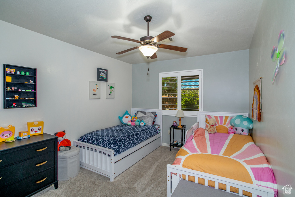 Carpeted bedroom featuring ceiling fan