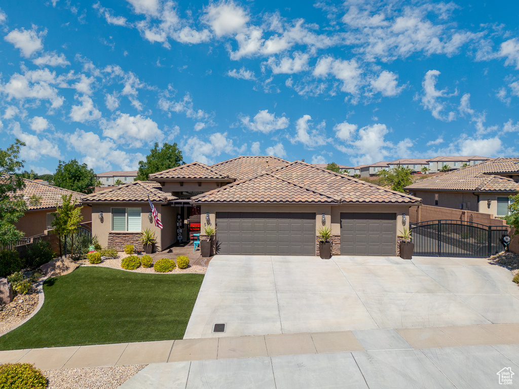 View of front of home with a garage and a front yard