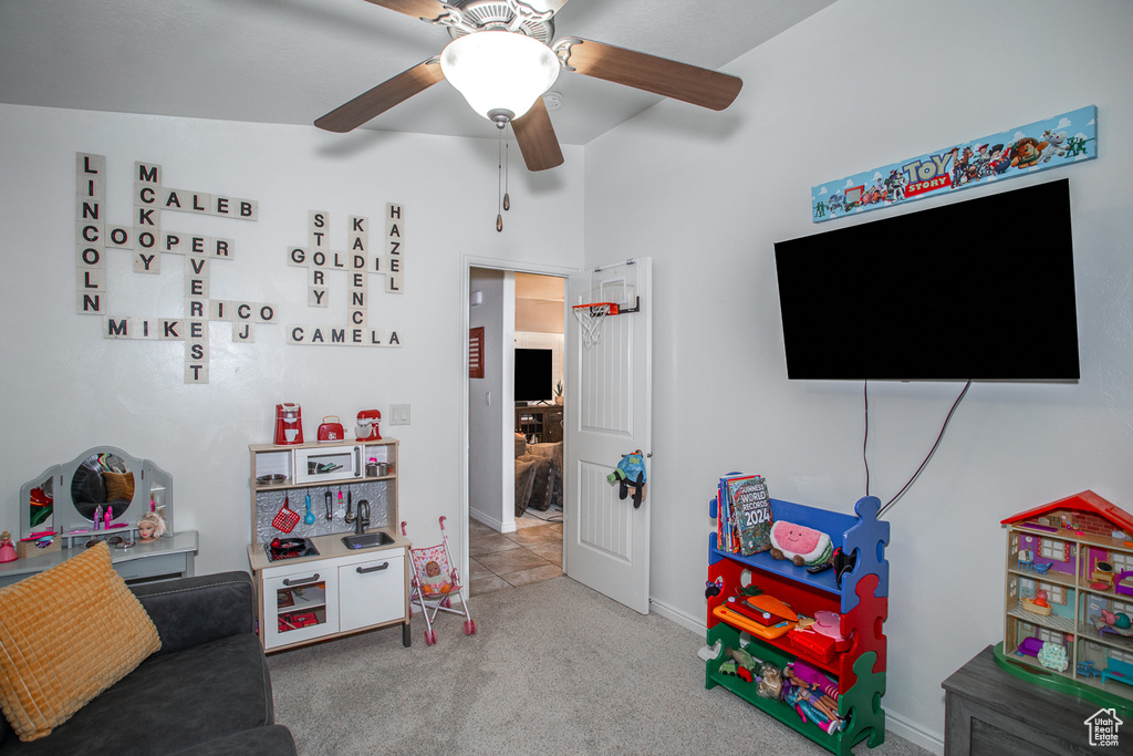 Recreation room with carpet floors, ceiling fan, and vaulted ceiling