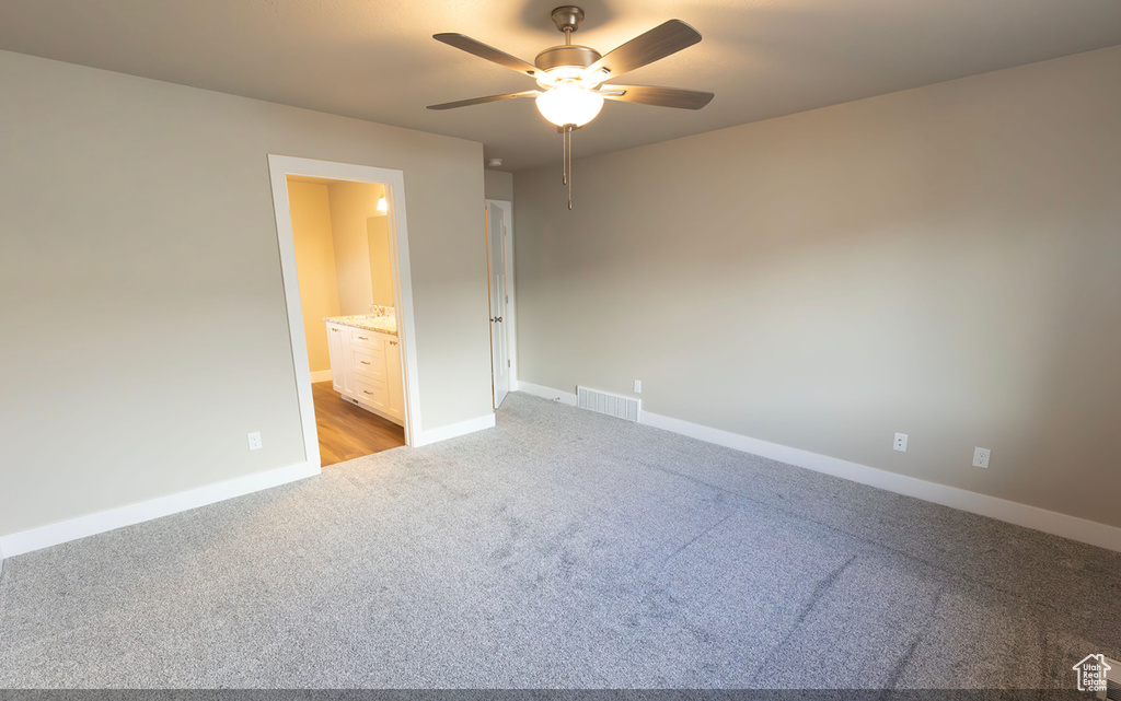 Unfurnished bedroom with carpet flooring, ensuite bath, and ceiling fan