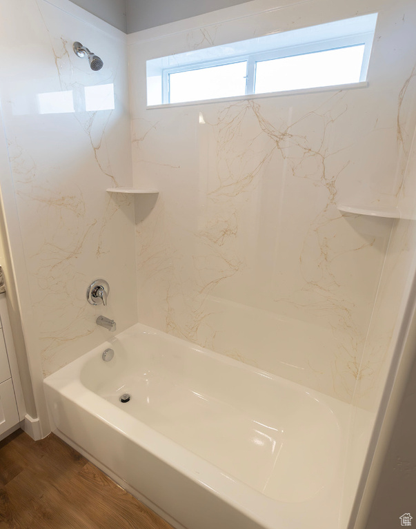 Bathroom featuring washtub / shower combination and hardwood / wood-style flooring