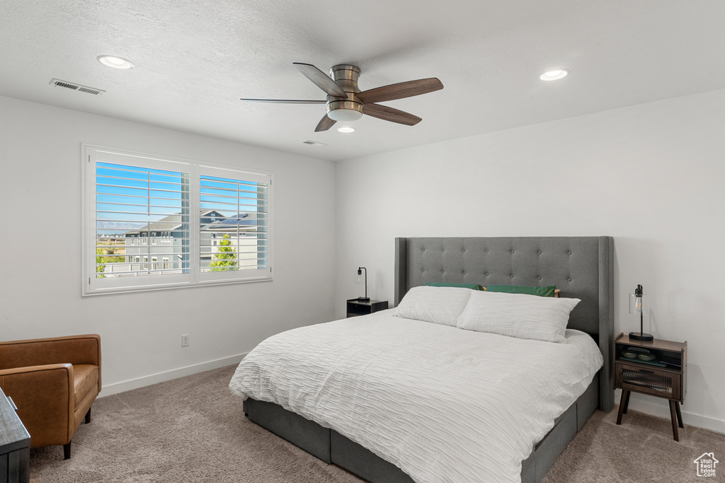 Carpeted bedroom featuring ceiling fan