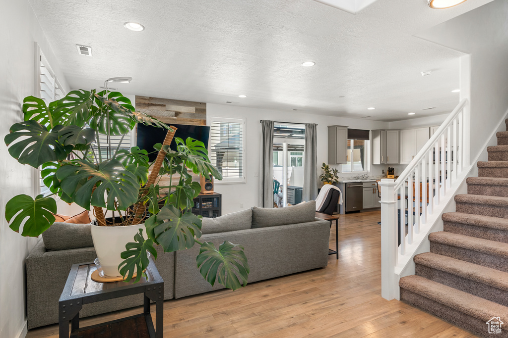 Living room with light hardwood / wood-style flooring and a textured ceiling