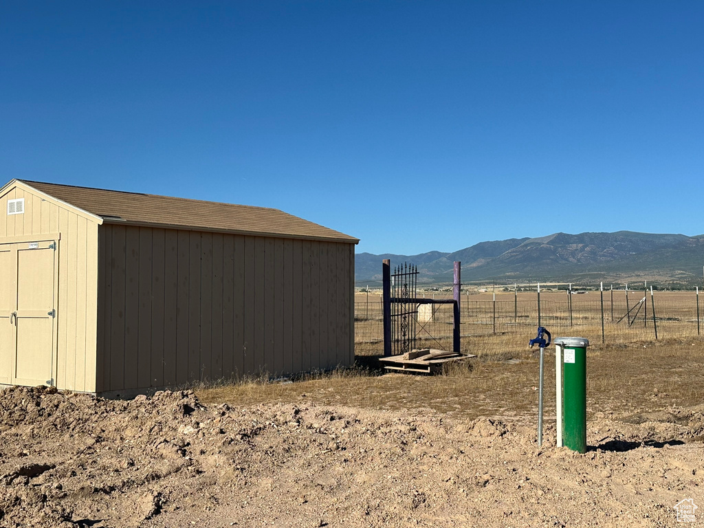 Exterior space with a mountain view, a shed, and a rural view