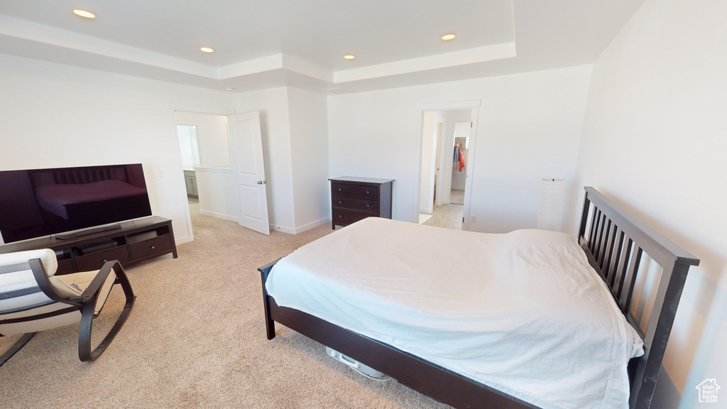 Carpeted bedroom with a tray ceiling