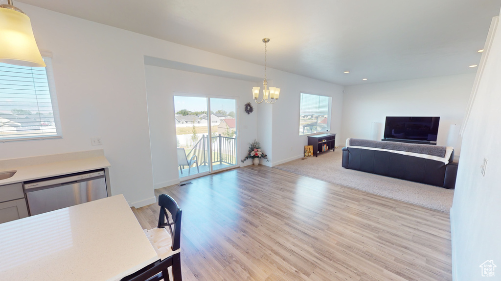 Living room with an inviting chandelier and light hardwood / wood-style floors