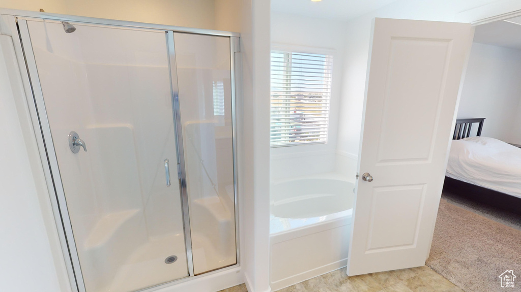 Bathroom with independent shower and bath and tile patterned flooring