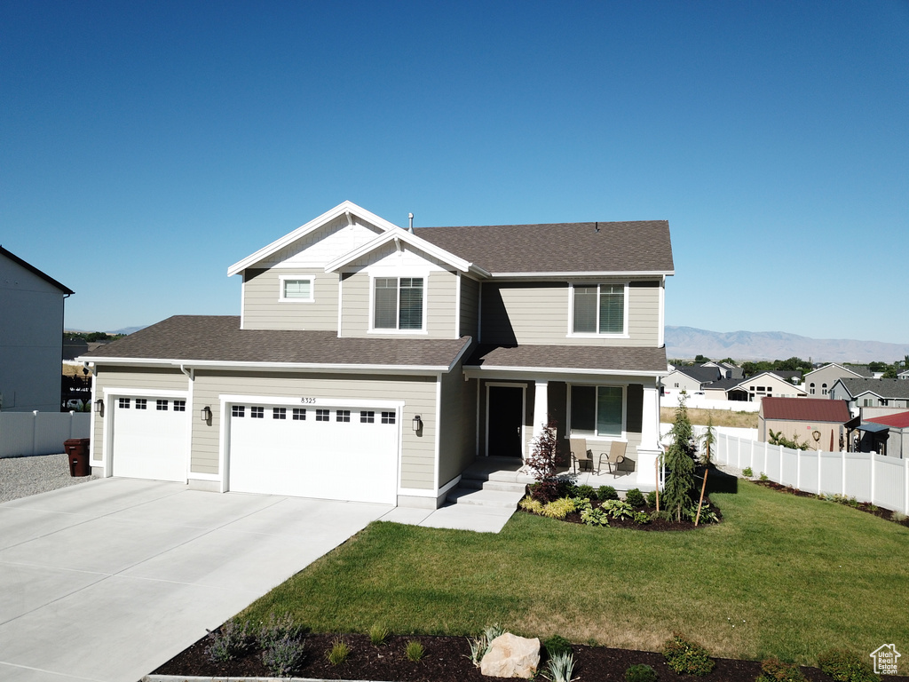 View of front of home with a mountain view and a front lawn