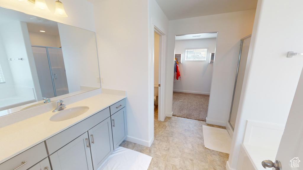 Bathroom with a shower with shower door, vanity, and tile patterned flooring