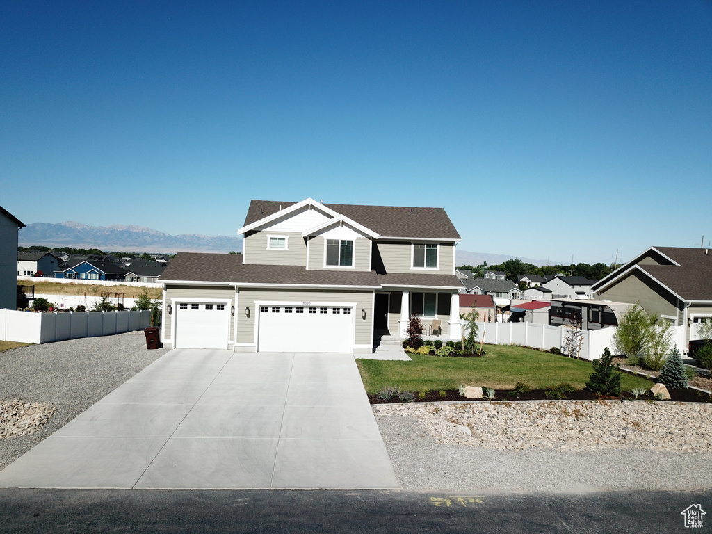 Front facade with a mountain view, a garage, and a front lawn