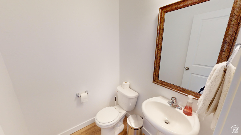 Bathroom featuring hardwood / wood-style flooring, toilet, and sink