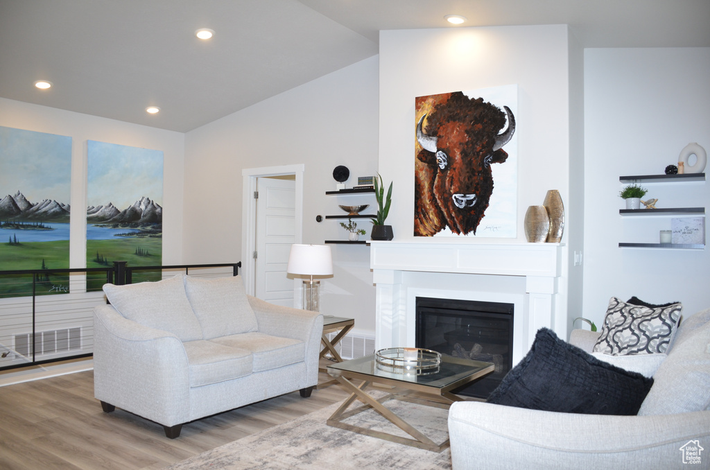 Living room featuring hardwood / wood-style flooring and vaulted ceiling