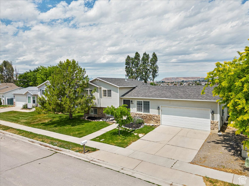 View of front of home with a garage and a front yard