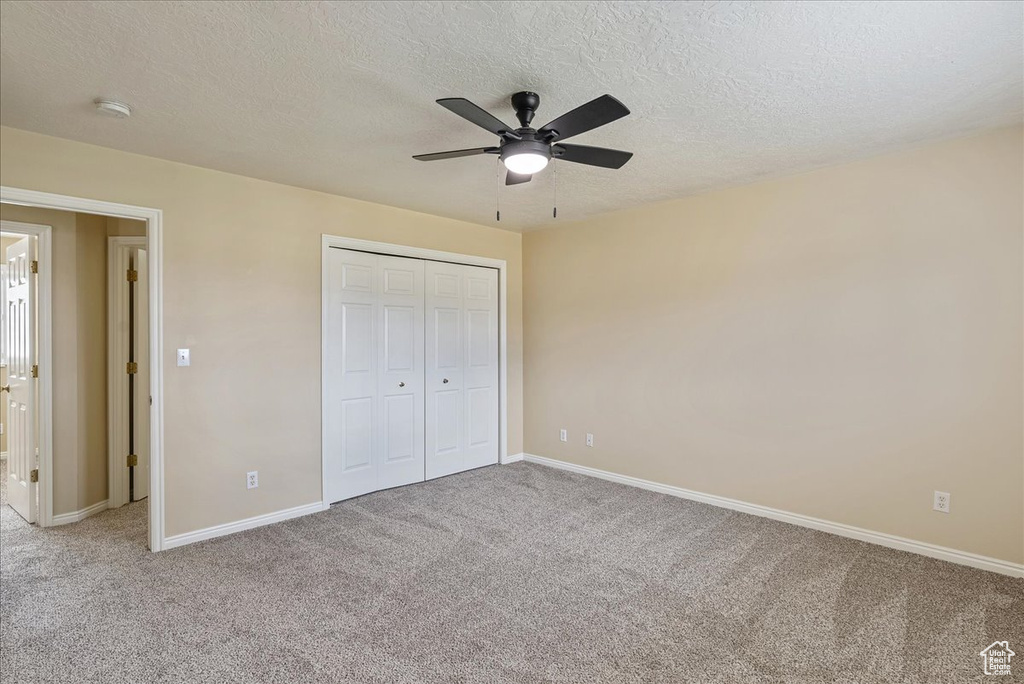 Unfurnished bedroom featuring carpet, a closet, and ceiling fan