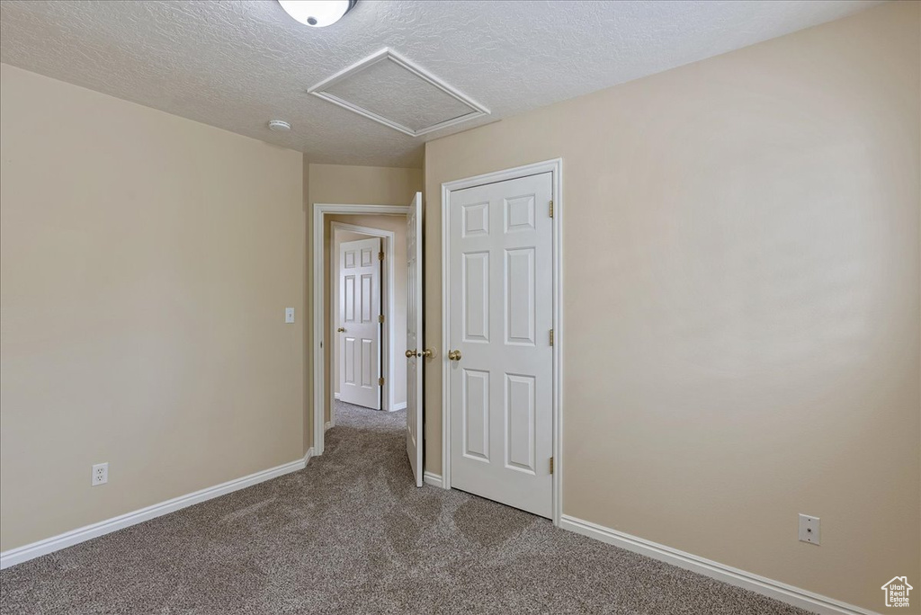 Empty room featuring carpet floors and a textured ceiling