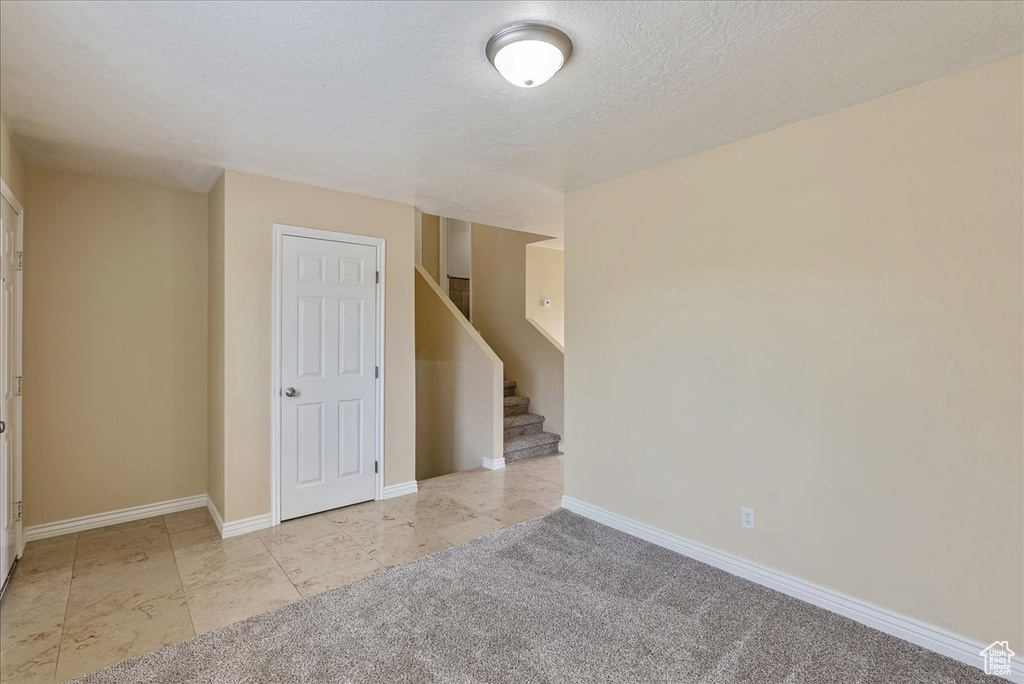 Tiled spare room with a textured ceiling