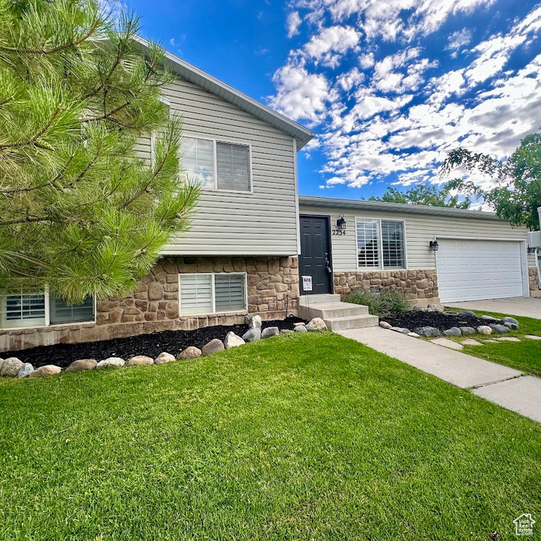 Split level home featuring a front lawn and a garage