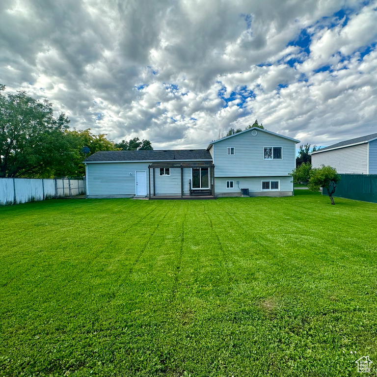 Rear view of property featuring a yard