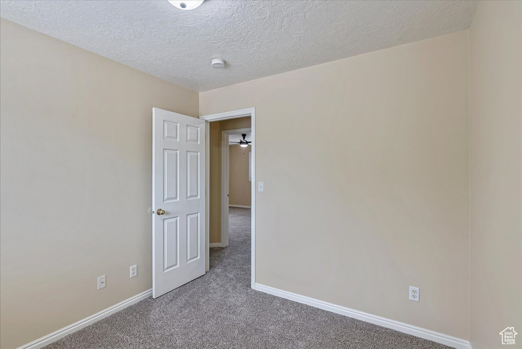 Carpeted empty room with a textured ceiling