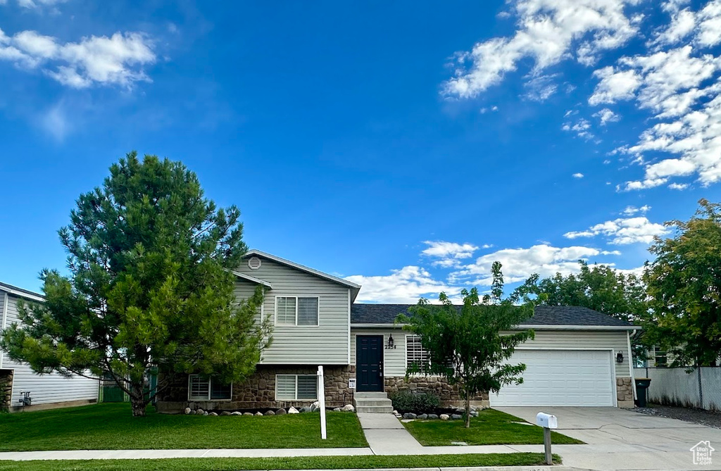 Tri-level home with a garage and a front yard