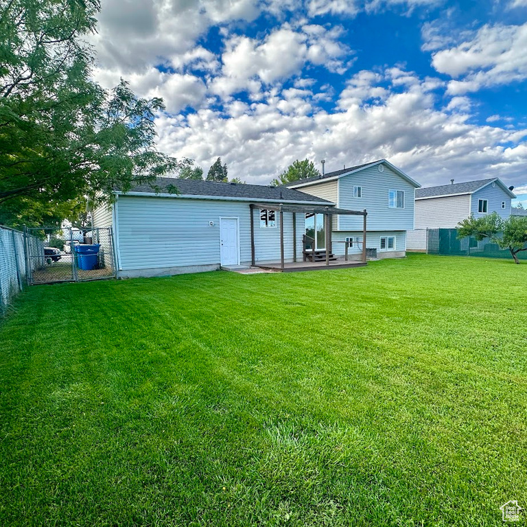 Rear view of house with a patio and a yard