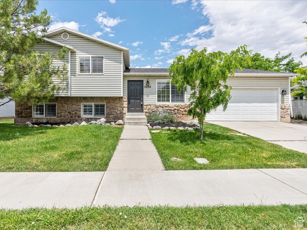 Split level home with a garage and a front yard