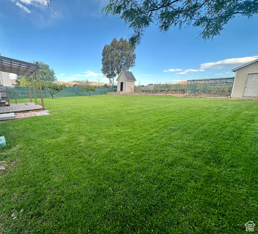 View of yard featuring a pergola, a deck, and a shed